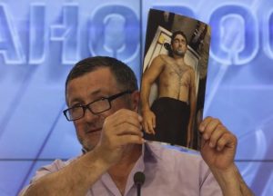 Ibragim Todashev’s father, displaying an autopsy photo of his son.