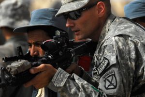 US Army Sargent and Afghan National Police officer during training at Chahar Dara, Afghanistan, on Aug. 28, 2010. Photo credit:  US Navy / Wikimedia (Public Domain)