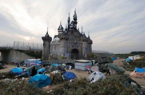 Photo by Banksy: Dismaland's dilapidated castle surrounded by tents. New shelters to come