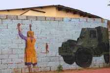 Wall art of young boy and protester about to be mowed down by military tanks.
Photo credit: Adapted by WhoWhatWhy from Nagarjun Kandukuru / Flickr (CC BY 2.0)