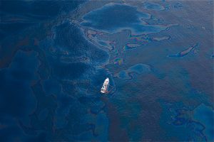 A ship floats in a sea of spilled oil in the Gulf of Mexico after the BP Deepwater Horizon oil spill. Photo by Kris Krüg. 