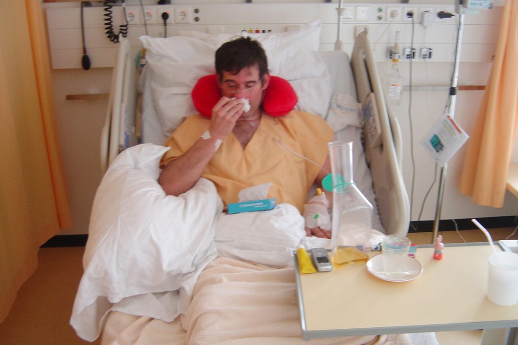 Sick man recovers in hospital bed
