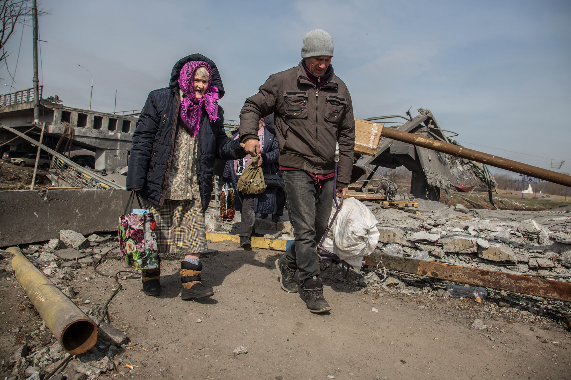 Ukraine, displaced, older woman, wrecked bridge