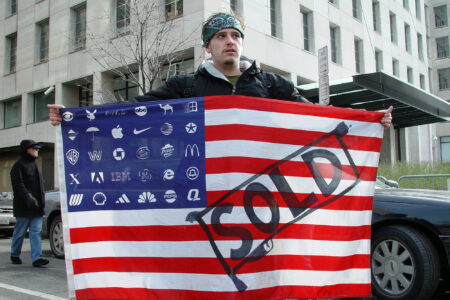 Protester, holding, Adbusters Corporate American Flag