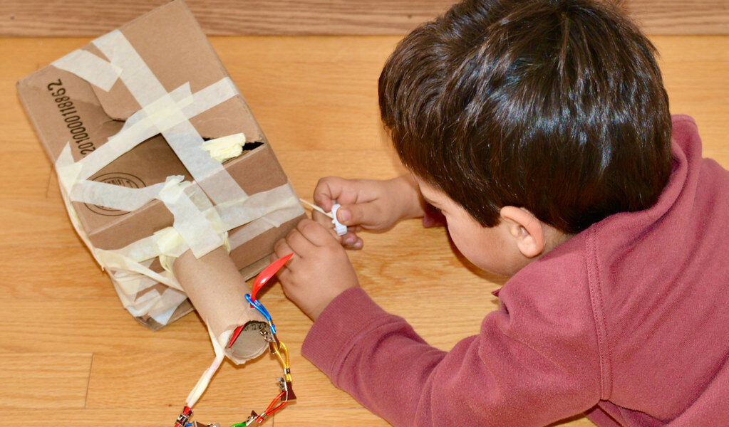 child with cardboard toy