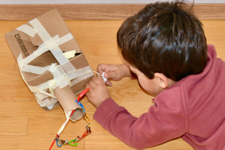 child with cardboard toy