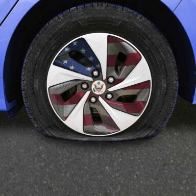 USA branded car, flat tire, American flag