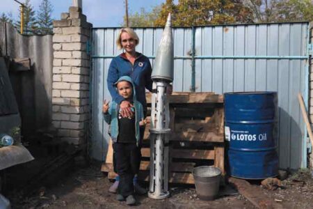 A boy and his mother, display shell of a missile, Kharkiv