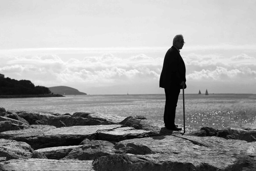 Man standing, rocky sea shore